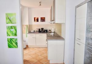 een kleine keuken met witte kasten en een tegelvloer bij Manitius 9, DD-Friedrichstadt (Zentrumsnah) in Dresden