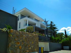Casa blanca con pared de piedra en Apartment Pipe en Malinska
