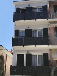 un edificio blanco con balcones negros. en Casa Mara en Chioggia