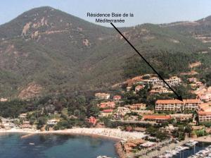 a view of a beach with mountains in the background at Plage de Miramar in Théoule-sur-Mer