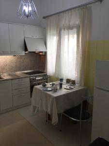 een keuken met een tafel met een tafelkleed erop bij Cosy Seaside Apartment in Kavala