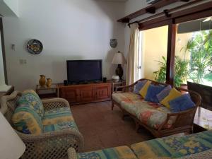 salon z kanapami i telewizorem z płaskim ekranem w obiekcie Casa Amarilla Playacar 1 w mieście Playa del Carmen