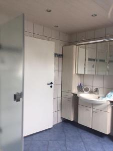 a bathroom with a sink and a white door at Haus Steffens in Esens +16 photos