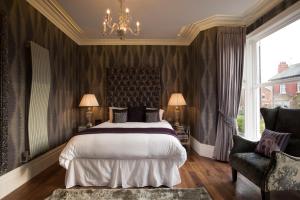 Un dormitorio con una cama y una silla y una ventana. en Mode Breck Apartments, en Poulton le Fylde
