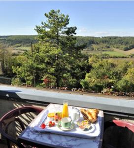 una mesa con bandeja de desayuno en el balcón en Le Compostelle en Vézelay