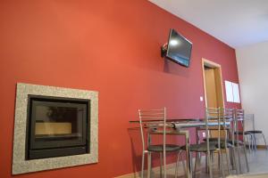 a dining room with red walls and a fireplace at Casa Pereira in Geres