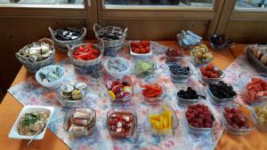 a table with bowls of fruits and vegetables in plastic containers at Alpengasthof Hoiswirt in Modriach