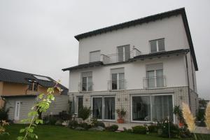 a white house with windows and a yard at Pension Lamme in Braunschweig +6 photos