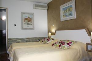 ein Schlafzimmer mit einem Bett mit zwei Kissen darauf in der Unterkunft Athénopolis in Grimaud