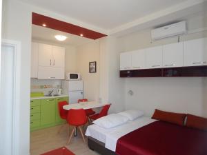 a bedroom with a bed and a table and a kitchen at Vila Matej in Ražanj