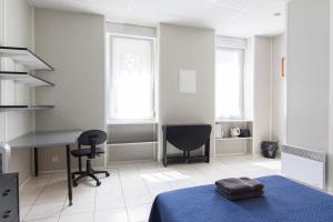 1 dormitorio con cama, escritorio y silla en Résidence Carpe Diem, en Marsella
