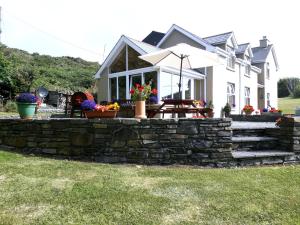 a house with a stone wall and a patio at Atlantic House B&B in Skibbereen