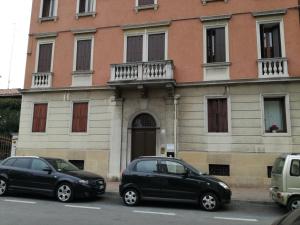 due auto parcheggiate in un parcheggio di fronte a un edificio di b&b Wu Giada a Mestre