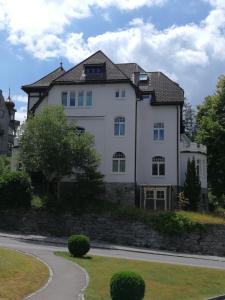 a large white house on the side of a road at Stilvolle 3-Zimmer Wohnung in Jugendstilvilla in Flims
