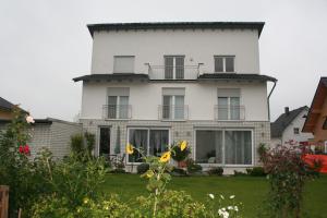 ein weißes Haus mit Fenstern und einem Hof in der Unterkunft Pension Lamme in Braunschweig