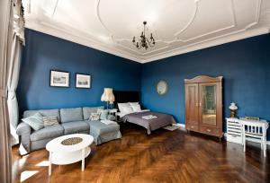 - un salon avec des murs bleus et un canapé dans l'établissement Wilhelmstadt Apartment 90m - PARKING, à Toruń