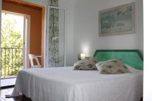 1 dormitorio con 1 cama blanca y 2 almohadas en Athénopolis, en Grimaud
