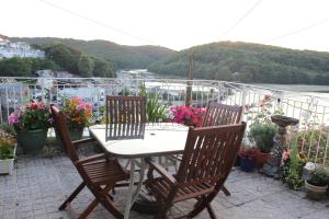 a table and chairs on a patio with flowers at Silver Birch in Looe