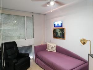 マルベーリャにあるMarbella 2000 Elegant Apartmentの紫色のソファと椅子が備わるリビングルーム