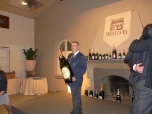 a man in a suit holding a bottle of wine at Bergamum F.L. in Bergamo