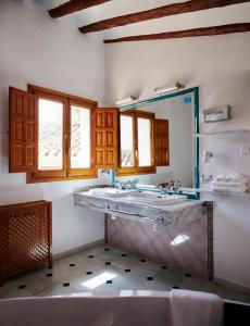 Un baño con un lavabo grande y un espejo. en Hotel Casa de los Arcos, en Vélez Blanco