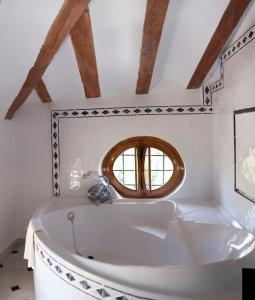 baño con bañera blanca y ventana en Hotel Casa de los Arcos, en Vélez Blanco