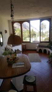 a living room with a table and some palm trees at Casas Perla & Maribel in Valle Gran Rey