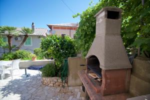 - un four à pizza extérieur installé sur une terrasse dans l'établissement Apartmani Loreta, à Mali Lošinj