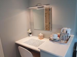 a bathroom with a white counter with a mirror at Greenside B&B in Westport