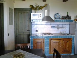 a kitchen with a sink and a stove top oven at Cottage Fuile 'E Mare in Orosei