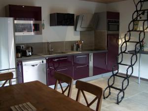 een keuken met paarse kasten en een tafel en stoelen bij Villa Némausa / Saint-Aygulf in Saint-Aygulf