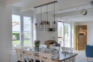 a dining room with a table and chairs and a clock at Holiday Home Cuylehoeve in Leffinge