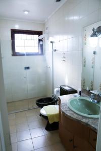 y baño con aseo, lavabo y ducha. en Piano B&B + Coworking, en Porto Alegre