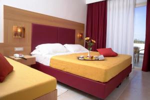 a hotel room with two beds with a tray of food at Hotel Degli Haethey in Otranto