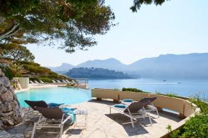 a pool with chairs and a view of the water at Hôtel Les Roches Blanches Cassis in Cassis