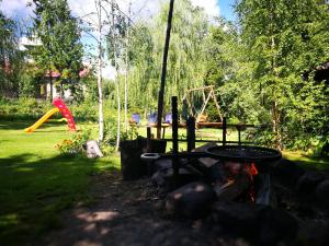 una hoguera en un patio con parque infantil en Agrowczasy u Mirusi en Wiżajny