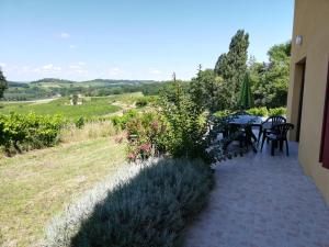 a patio with a table and chairs and a field at Les Vignes in Pomport