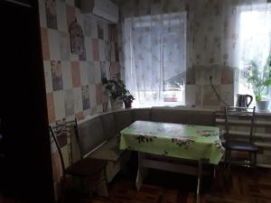 ProletarkaにあるU Iriny Guest Houseのテーブルと椅子、窓が備わる客室です。