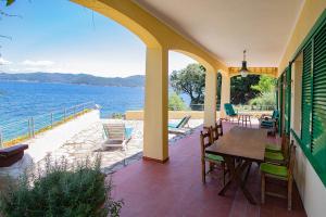a patio with a table and chairs and the water at Residenza Le Sprizze in Bagno