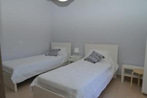1 dormitorio con 2 camas y mesa con lámpara en Tilemachos House near Corfu town, en Potamós
