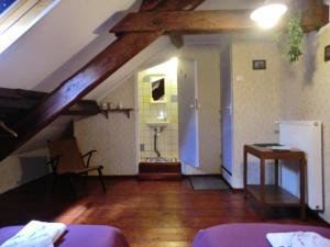een zolderkamer met een bed en een badkamer bij Sans Parure : Chambre d'hôte in Buxières-sous-Montaigut