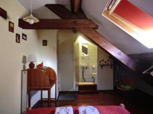 een zolderkamer met een bed en een badkamer bij Sans Parure : Chambre d'hôte in Buxières-sous-Montaigut
