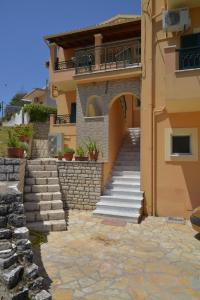 a house with stairs leading up to a building at Tilemachos House near Corfu town in Potamós