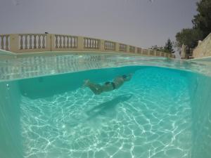 een persoon die zwemt in een zwembad bij B&B Verzavò in Cetraro