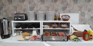 a table with a shelf with plates and food at Touring & Sport Hotel Siófok in Siófok