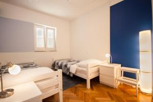 una camera con due letti e una parete blu di Ema a Baška