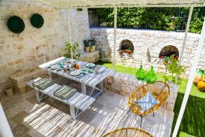 a patio with a table and chairs in a yard at Hermanas Relais - trulli luxury in Alberobello