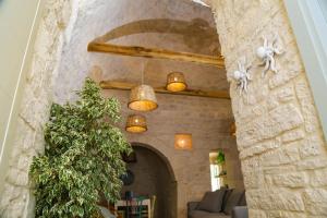 sala de estar con pared de piedra y sofá en Hermanas Relais - trulli luxury, en Alberobello