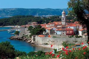a town next to a river with a clock tower at Old Town Apartment in Krk