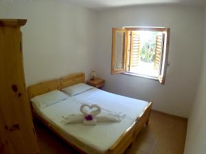 a bedroom with a bed with a heart decoration on it at Villaggio Camping La Scogliera in Ricadi +165 photos